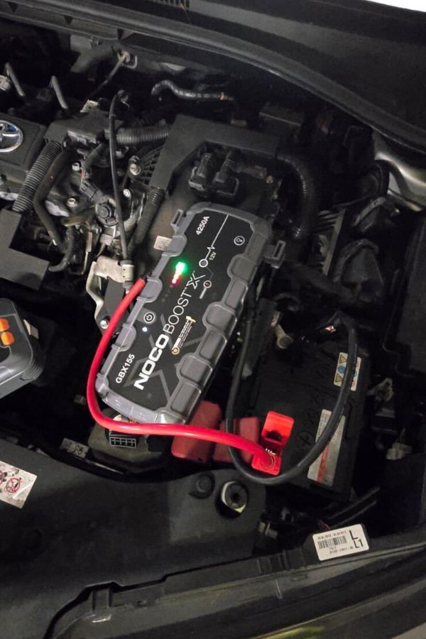 Prompt Recovery with a NOCO Boost X battery pack and jumper cables, jump-starting a car with a flat battery