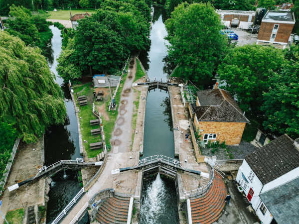 Rickmansworth canal and river with the slucegates in the foreground and houses and trees in the background