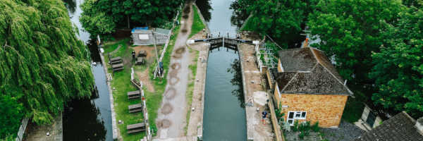 Rickmansworth canal and river with the slucegates in the foreground and houses and trees in the background